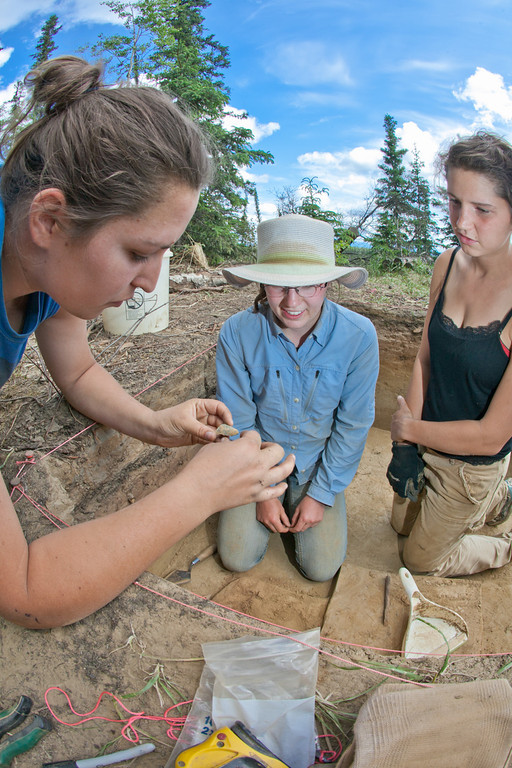 Allison Little, left, Erica Blake and Aurora Bowers inspect a stone tool uncovered during an archeaological field camp at a dig site near Delta Junction. | UAF Photo by Todd Paris