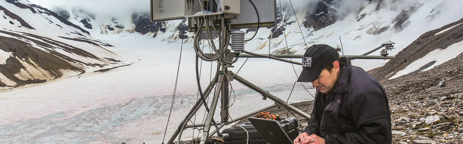 Research technician set up remote station atop glacier