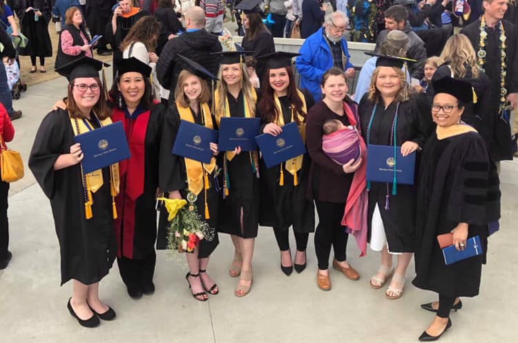 Social Work graduates pose with their diplomas after the commencement ceremony.