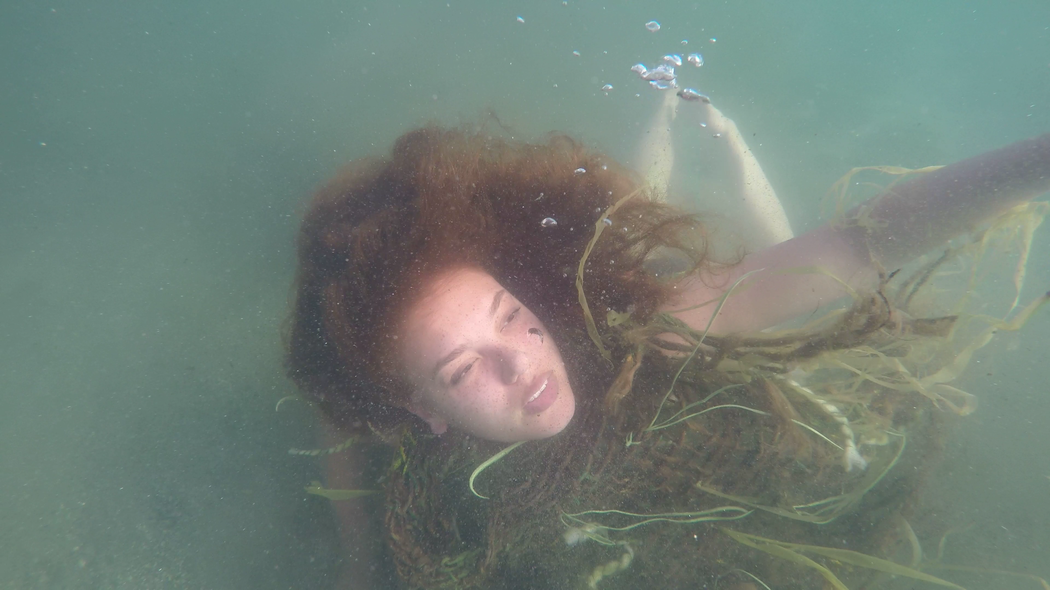 Girl under water with seaweed