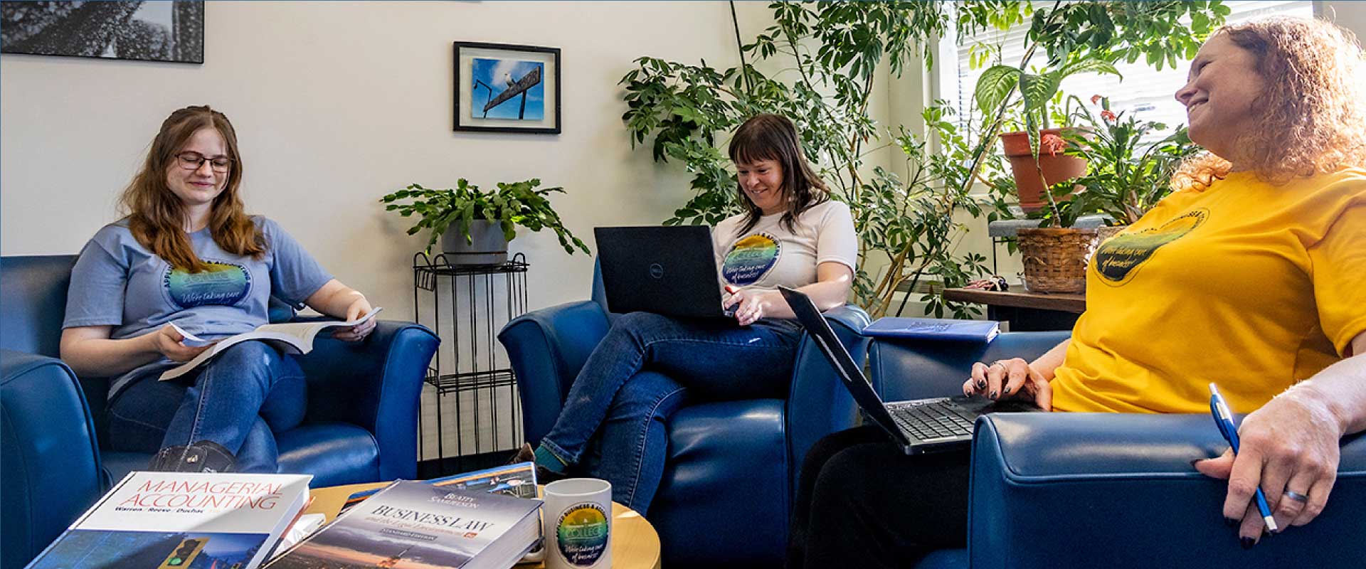 Students with laptops in a study lounge