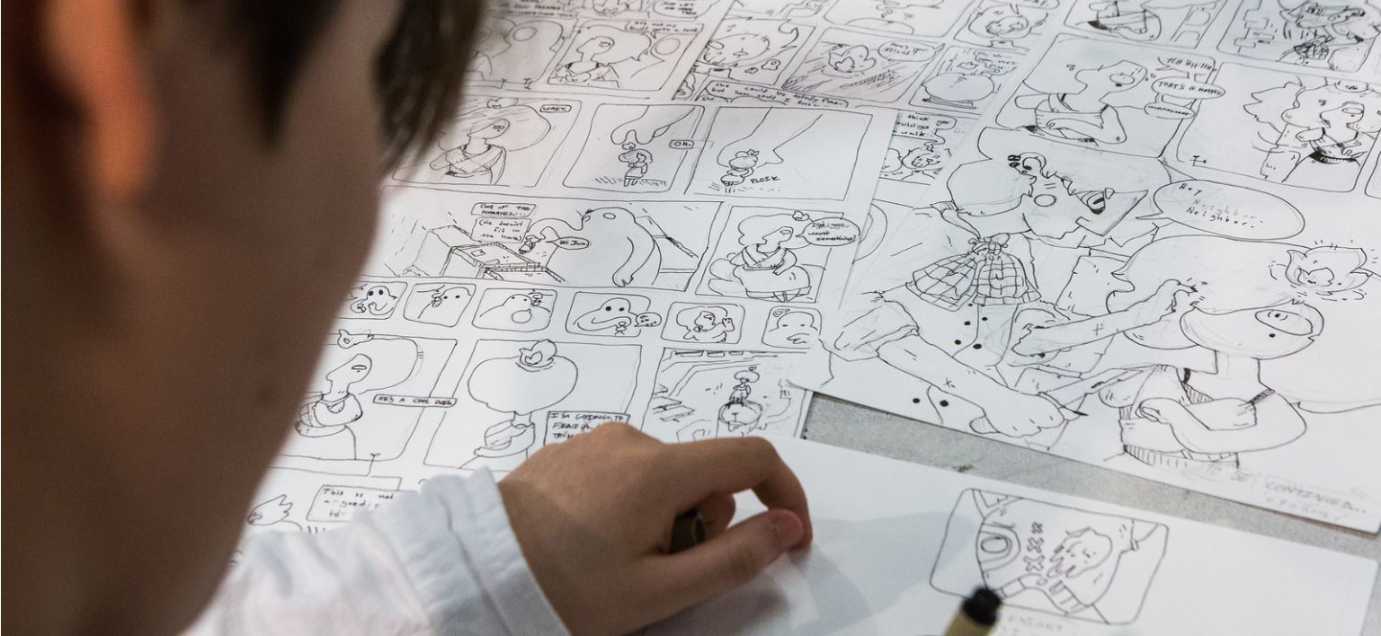 A Visual Art Academy student works on cartoons.