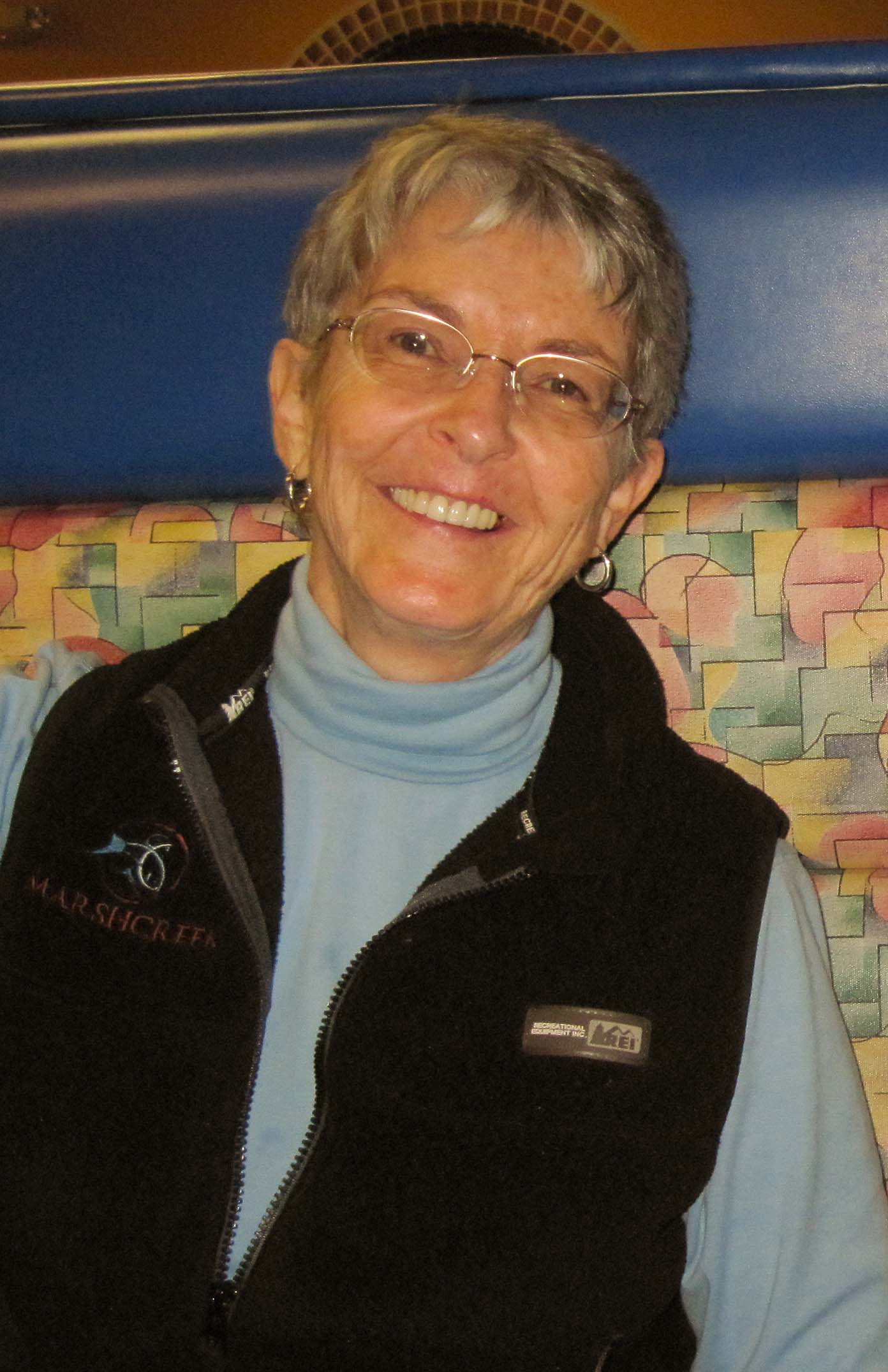 Clarissa Quinlan in glasses and black fleece vest smiles at camera