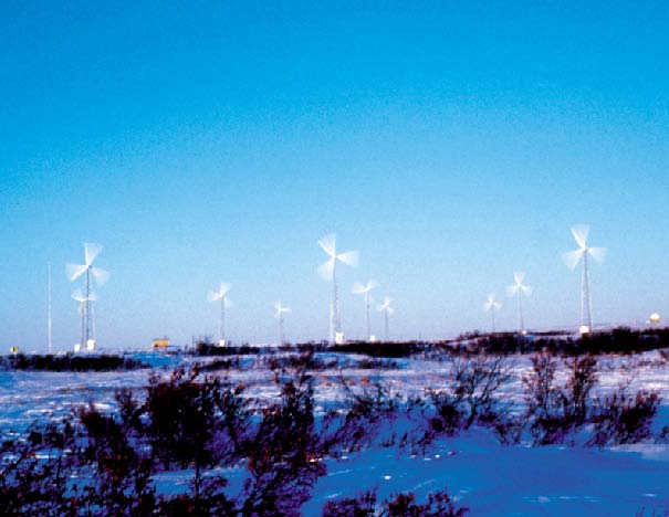 10 operating wind turbines in a snowy landscape with blue skies