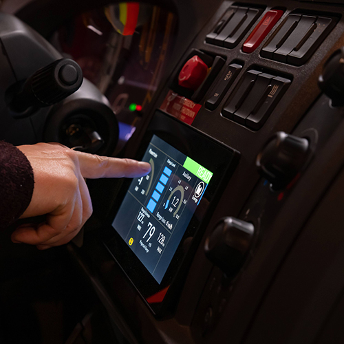 An electric vehicle driver adjusts control settings on the vehicle control screen. Photo Credit Tim Leach.