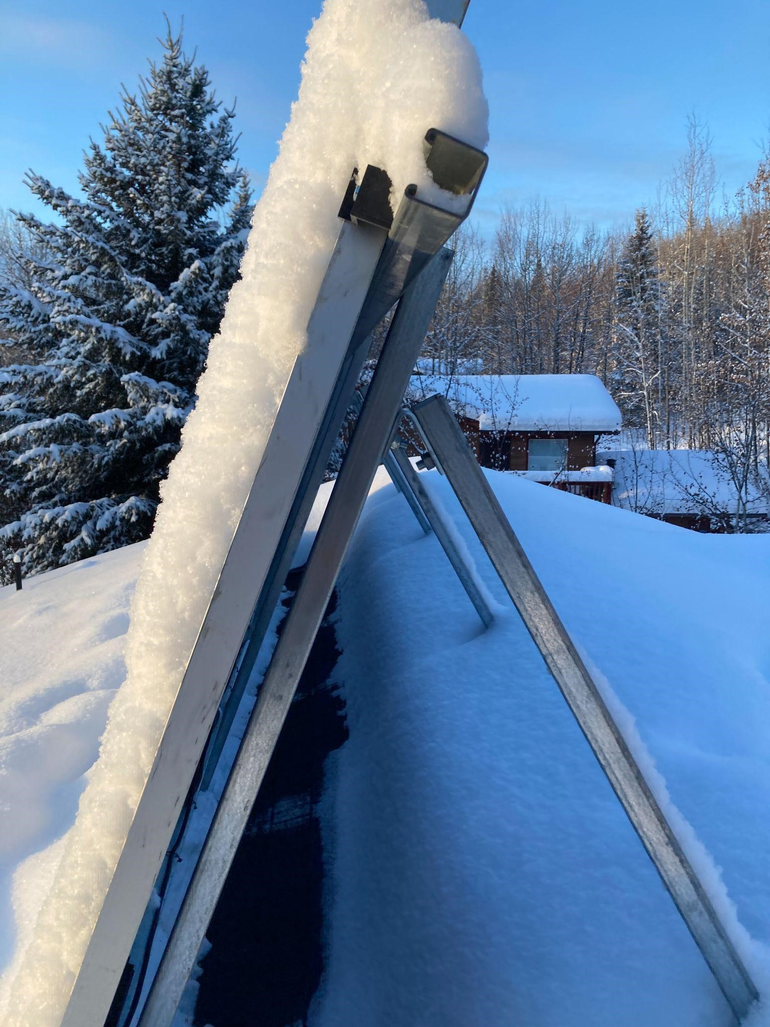 photo of snow-covered angled roof-top solar panel