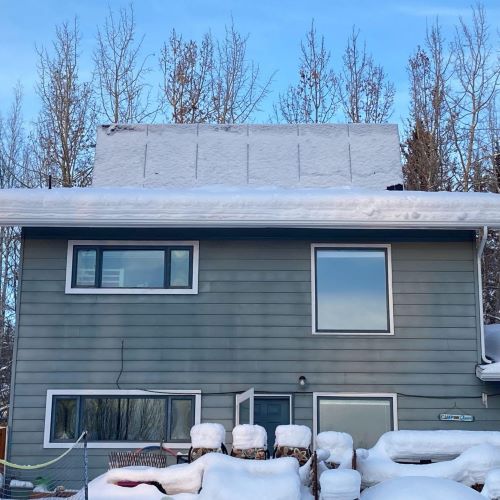 Wintertime image of a house in Fairbanks, Alaska with tilted roof-top mounted solar panels.