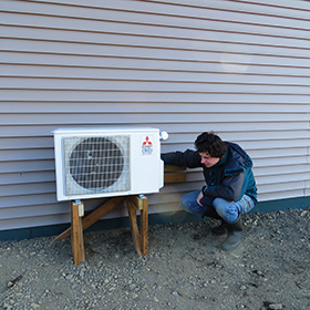 Tom Marisk inspecting a heat pump