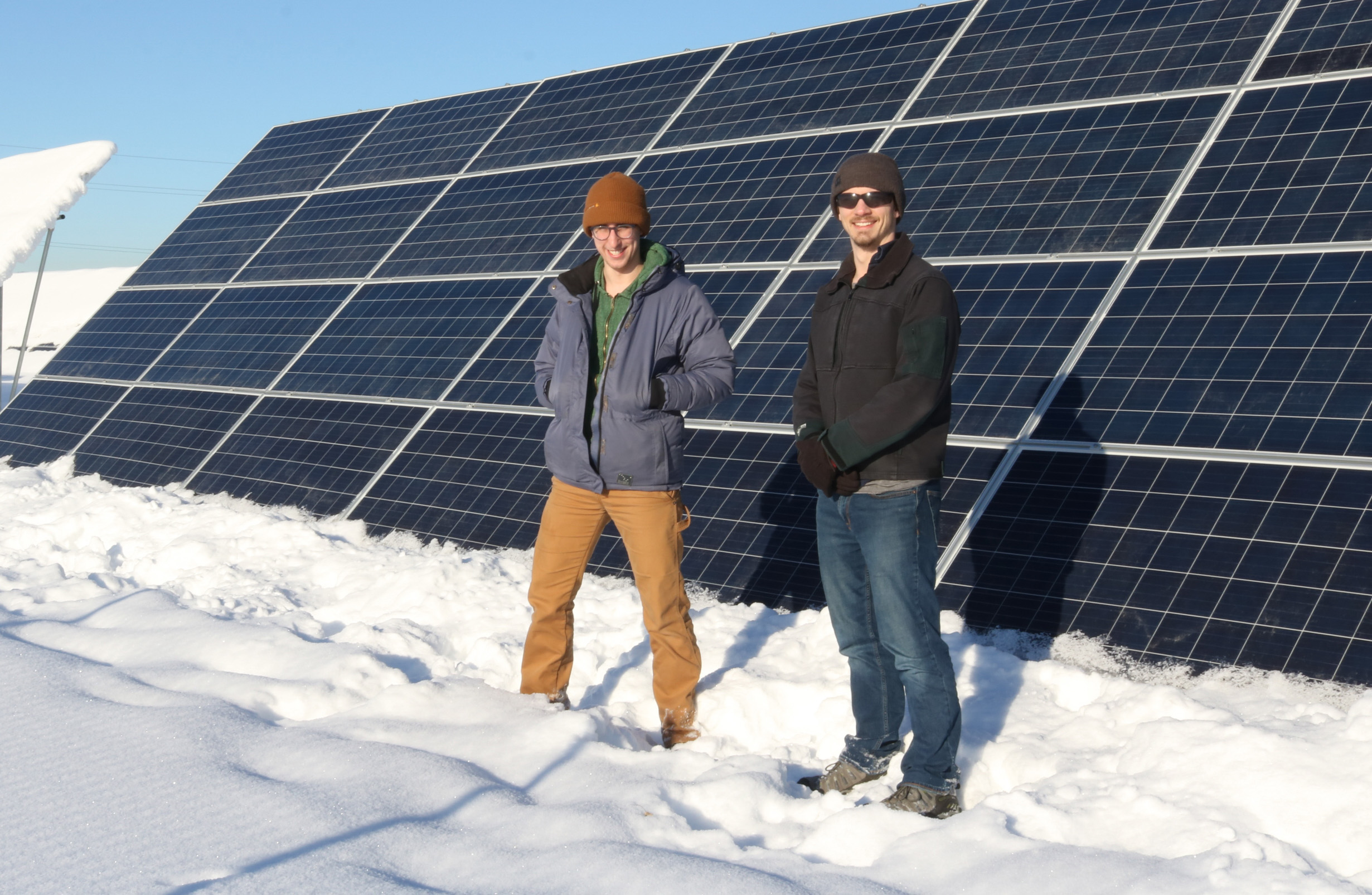 Two people standing in front of solar panels