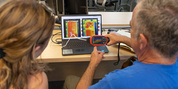 ACEP summer intern Kate Modler and Rich Strömberg look at thermal imaging data taken from solar photovoltaic panels.