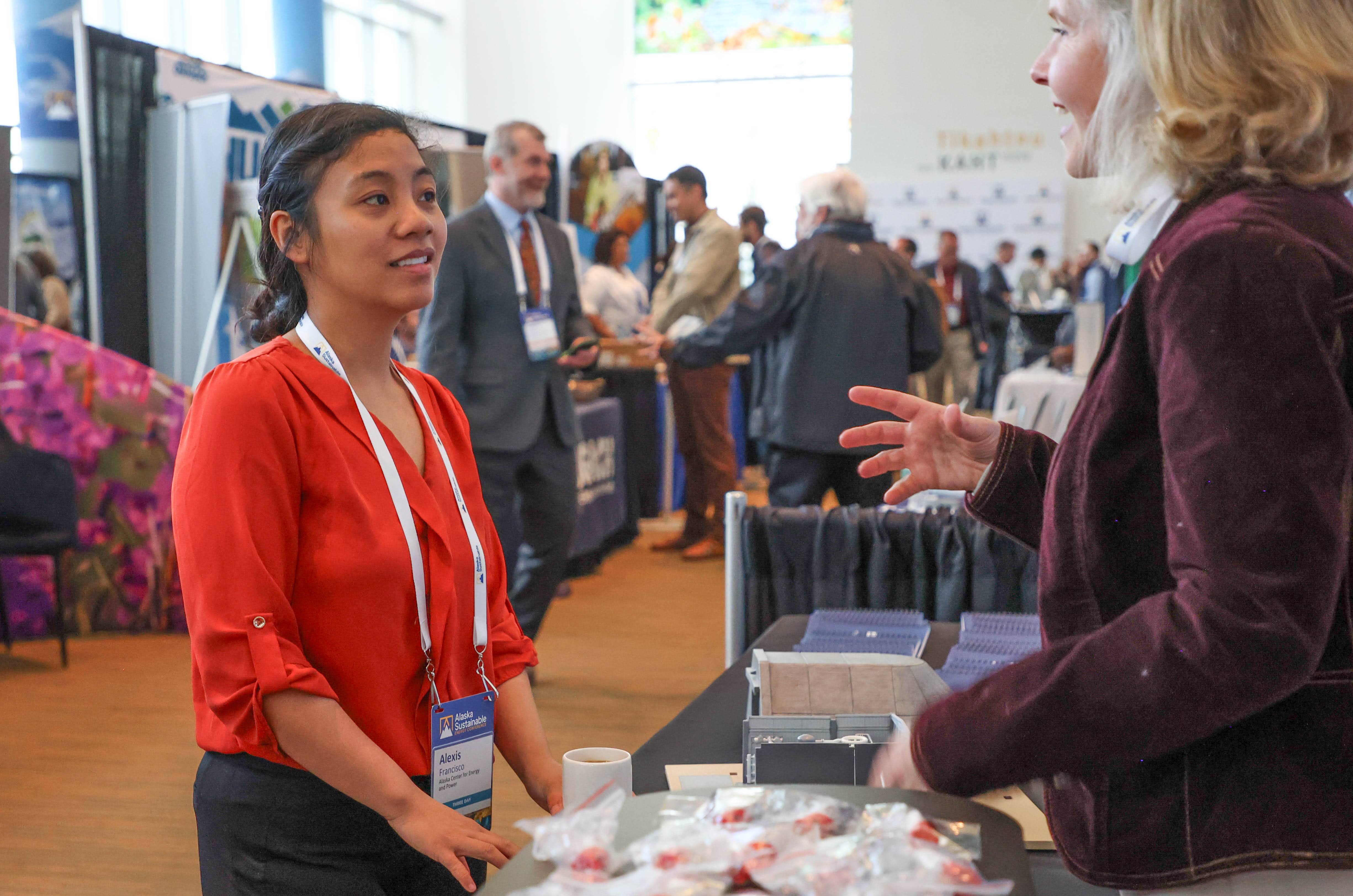 Alexis Francisco visits a vendor booth during the 2024 Alaska Sustainable Energy Conference.