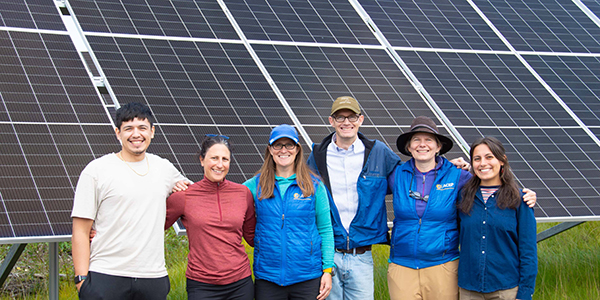 ACEP team members in front of a solar array 