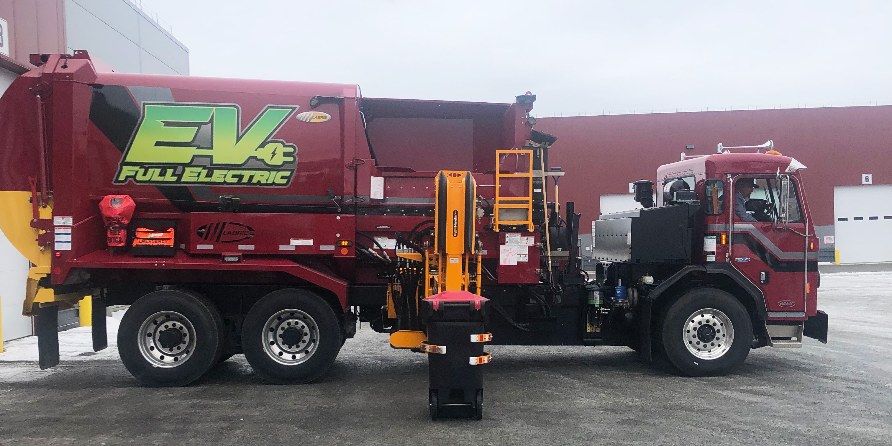 One of the Municipality of Anchorage Solid Waste Services’s brand new electric garbage trucks lifts a bin at the public launch. Photo by Michelle Wilber/ACEP.