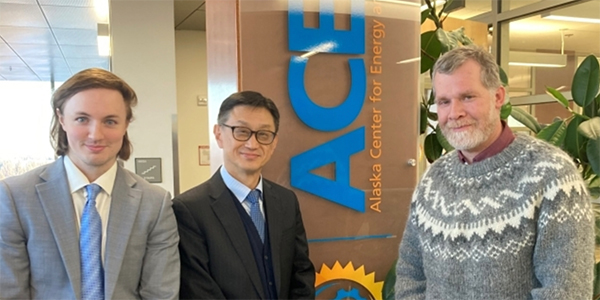 Three people stand in front of the ACEP office