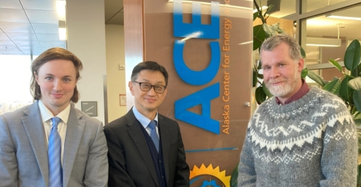 Three people stand in front of the ACEP office