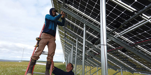 ACEP’s Chris Pike installs monitoring equipment on the Kotzebue Electric Association solar farm.