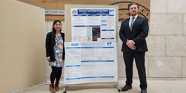 ACEP 2022 summer interns Alexis Francisco (left) and Leif Bredeson (right) stand by their posters at the Texas Power and Energy Conference. Photo by Phylicia Cicilio.