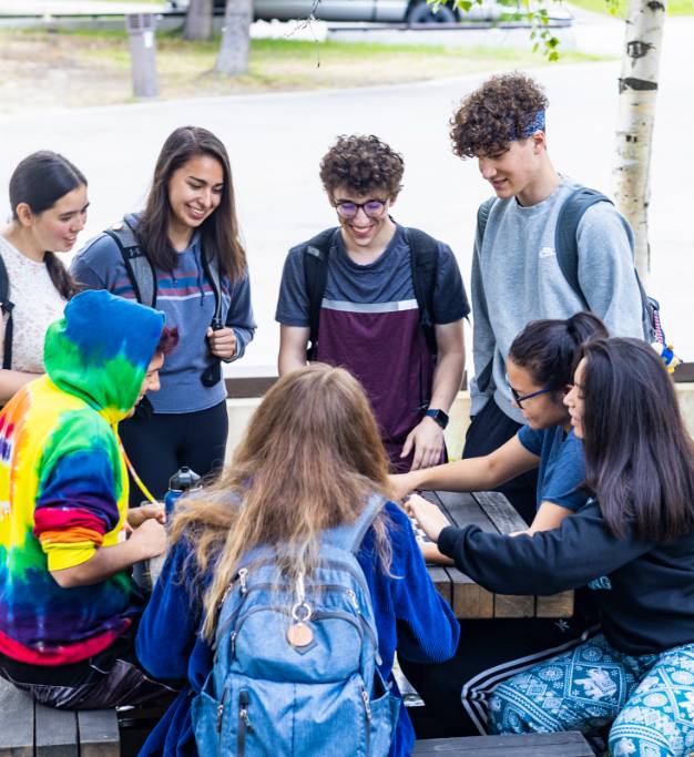 Students gathered around an outdoor chess table on the Fairbanks campus
