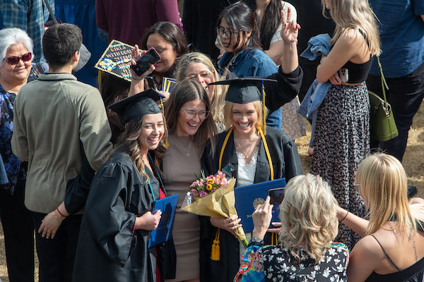 UAF graduates and their families embrace following the 2023 commencement ceremony at the Carlson Center