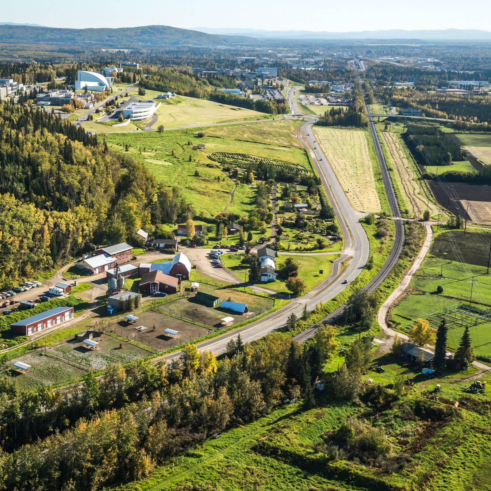 Aerial view of the Fairbanks Experimental Farm with UAF campus and hills behind it