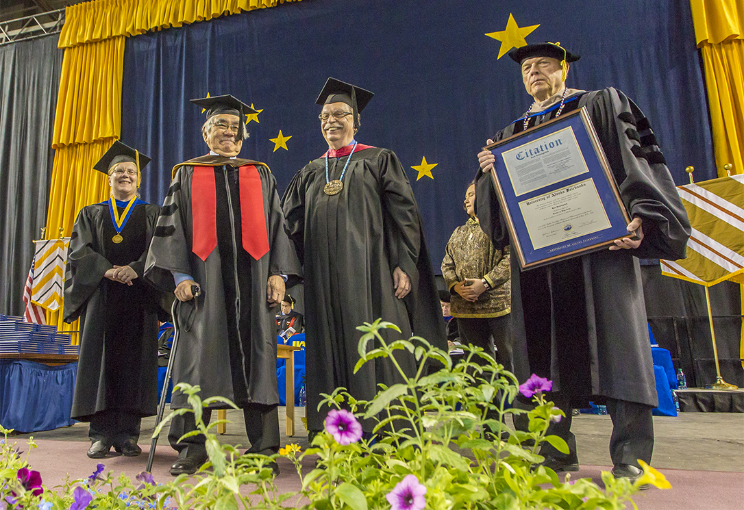 UA President Pat Gamble, right, presents an honorary Doctor of Fine Arts degree to Ron Senungetuk, second from left, at Commencement 2015, accompanied by Provost Susan Henrichs, far left, and Chancellor Brian Rogers, second from right.