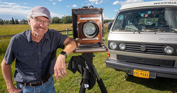 Charles Mason stands with his 8-by-10 camera and VW Syncro Westfalia Vanagon at Creamer’s Field in Fairbanks in August 2022. UAF photo by Eric Engman.