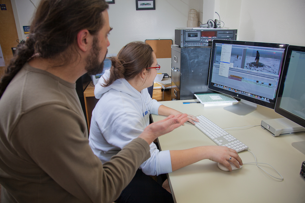 Sicoli works with graduate student Allison Little on her cultural anthropology project in an Eielson Building media lab. | UAF Photo by Todd Paris