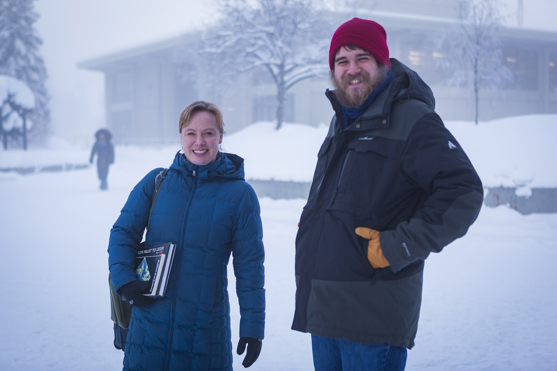 Dr. Zoe Jones with MFA student Max Bartsch walk across a snowy UAF campus