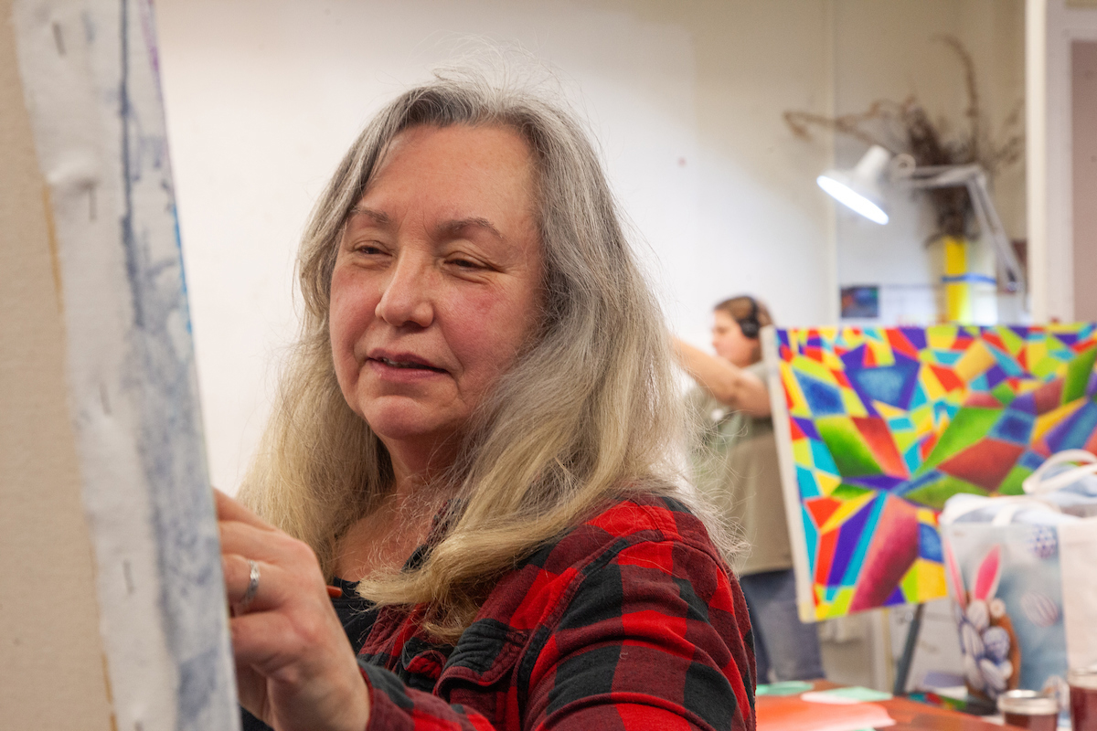 Susan Andrews works on her project in the painting studio Tuesday, December 5, 2023. UAF Photo by Sydney Jolin