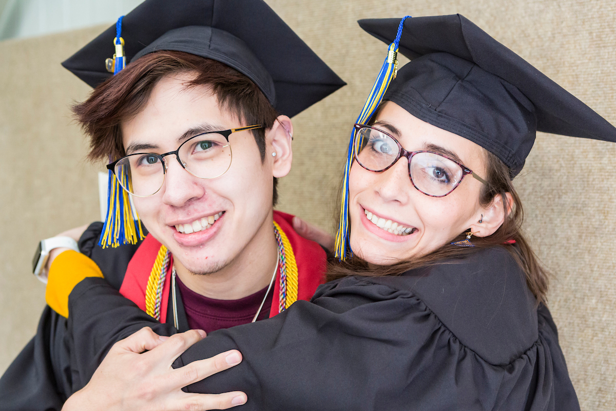 Ethan Lauesen, left, and Naomi Hutchens, who both earned bachelor's degrees in art, hug before the University of Alaska Fairbanks' 97th commencement ceremony at the Carlson Center on Saturday, May 4, 2019. UAF Photo by Sarah Manriquez.