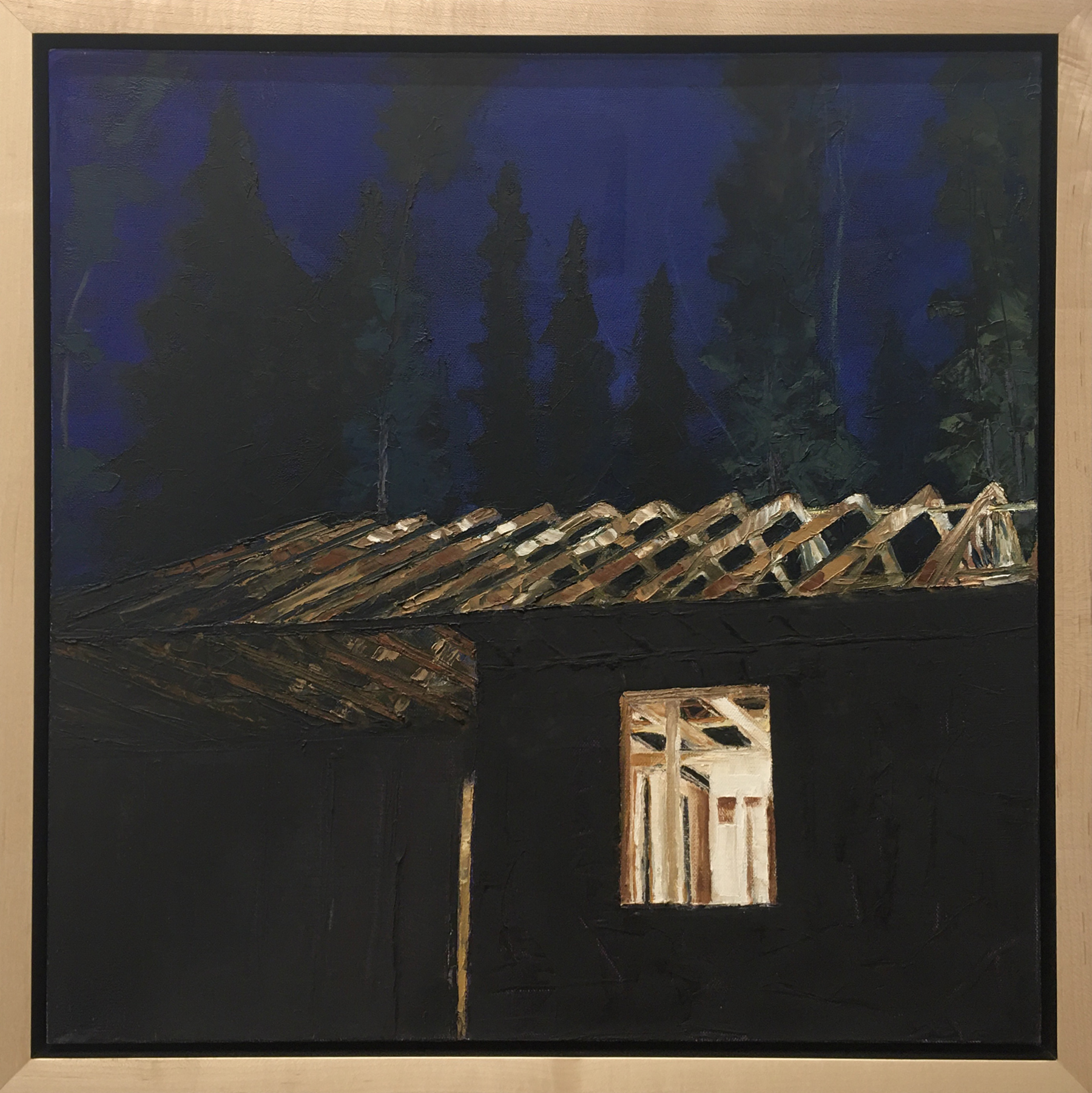 A frame of a house at night lit by an interior light. Photo courtesy of Allison Juneau