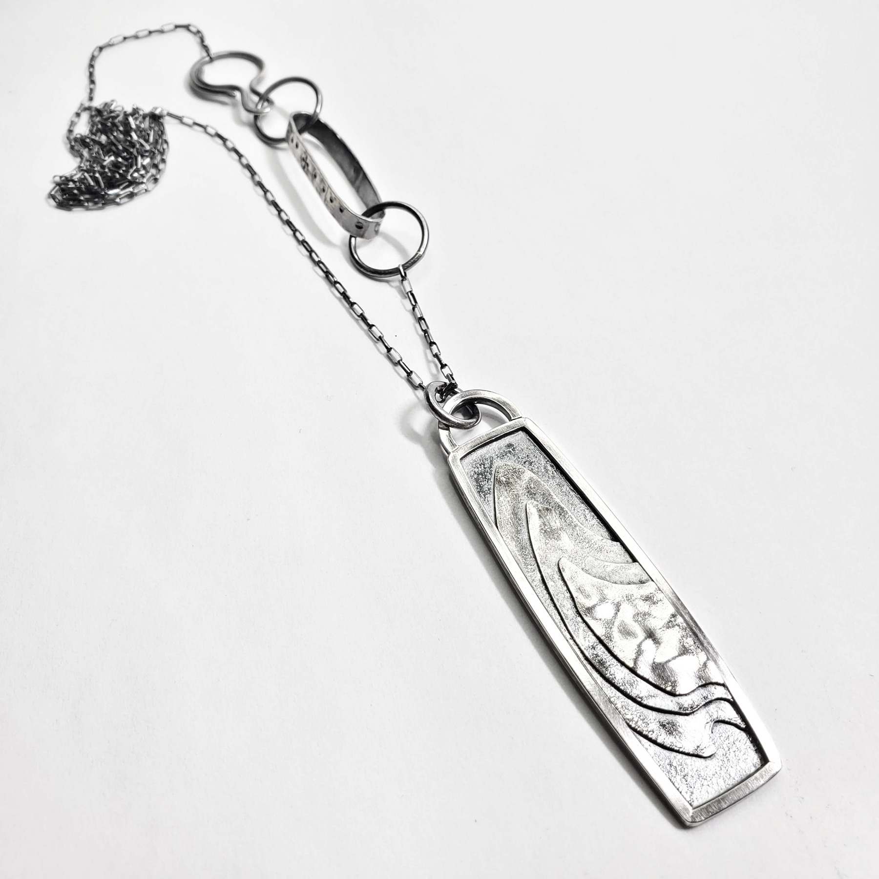 Silver Pendant with terrain design, image courtesy of Christen Booth
