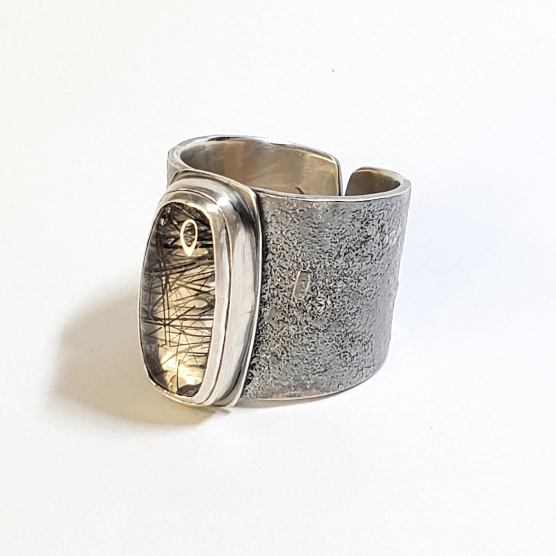 large silver textured ring with tourmaline rutile inside quartz, image courtesy of Christen Booth