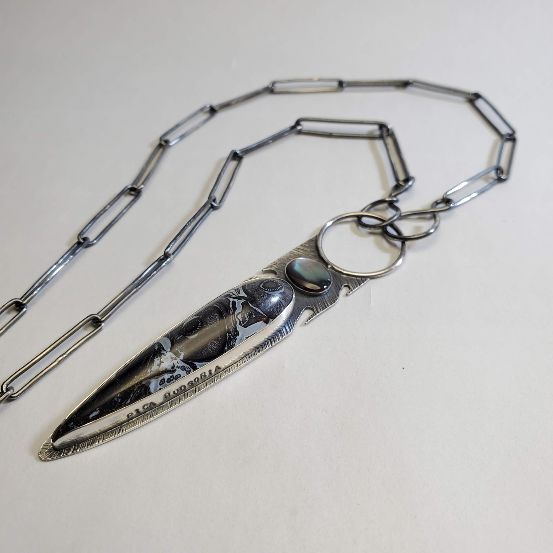 A sterling silver pendant with fossilized palm root and dark paua shell, image courtesy of Christen Booth