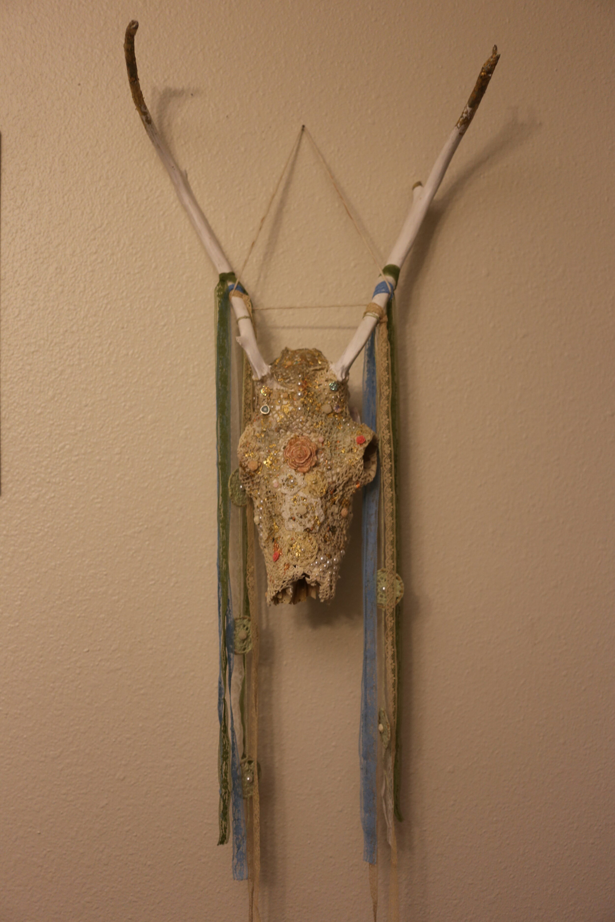 Caribou skull decorated with Lace, Embroidery, Doilies, Gold leaf and Found objects. image courtesy of Indi Walter