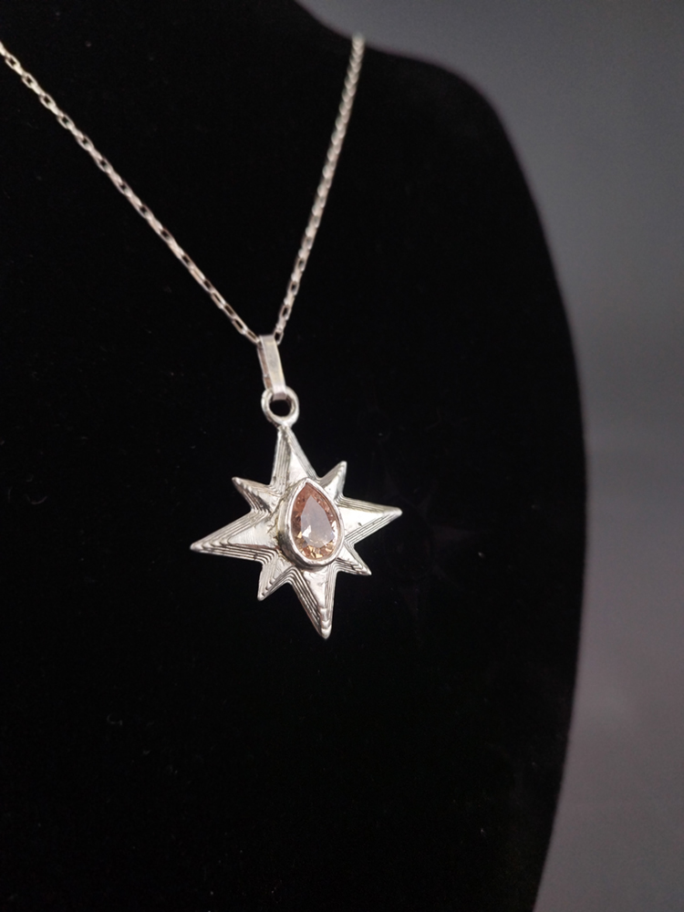 Gold star necklace with a morganite stone at the center. Image courtesy of the artist