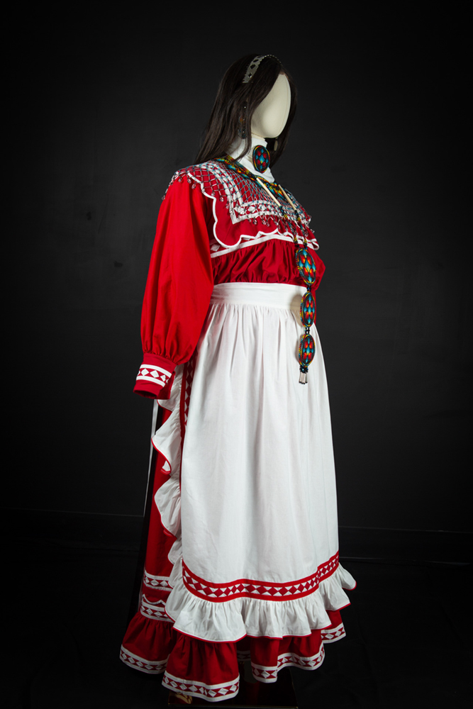 Red dress with white apron and Native American regalia hand sewn by Michelle Bailey. Image courtesy of the artist