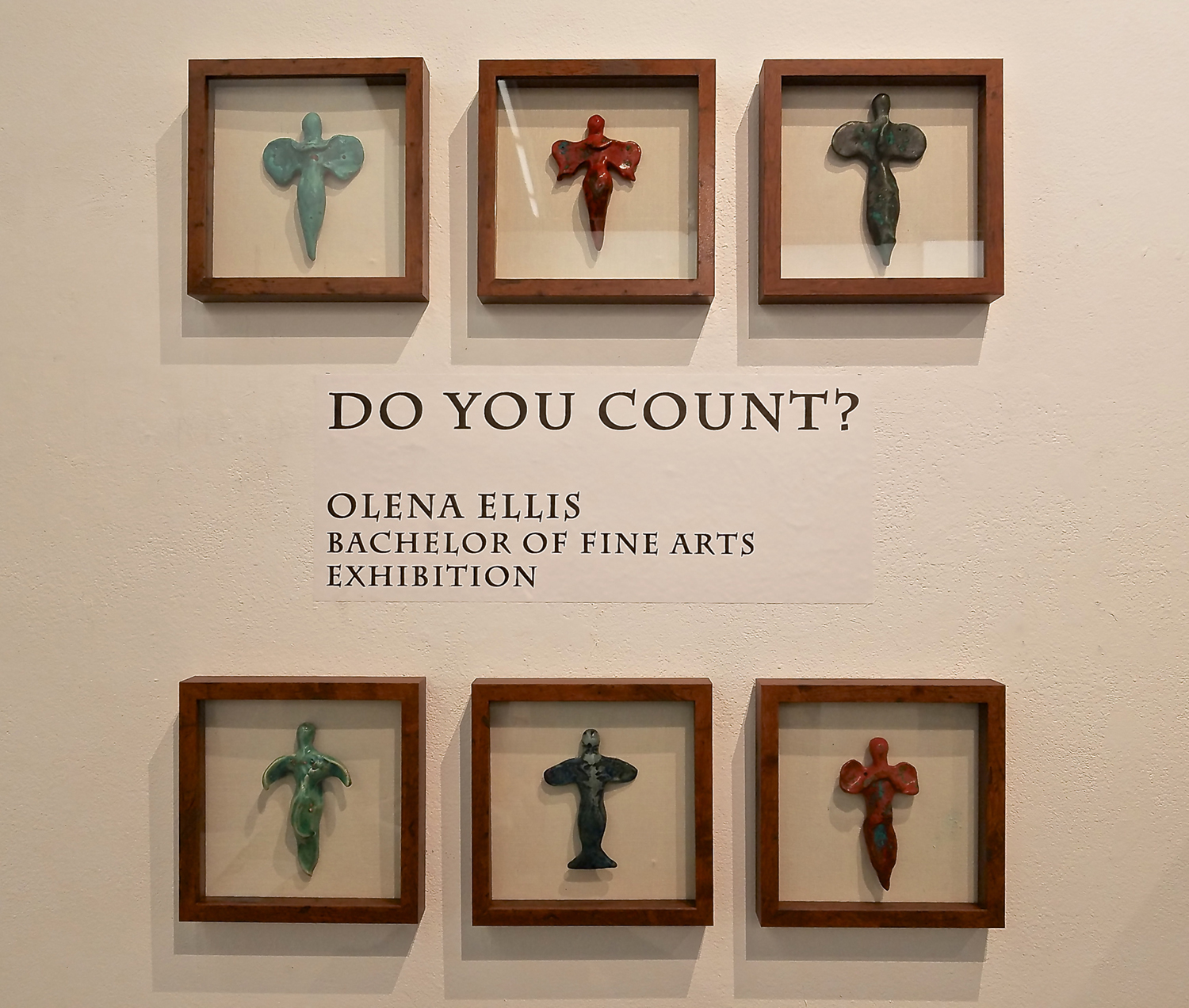 6 small ceramic goddesses, each in its own shadow box, surround the exhibit show title 'Do You Count?" Photo by Olena Ellis