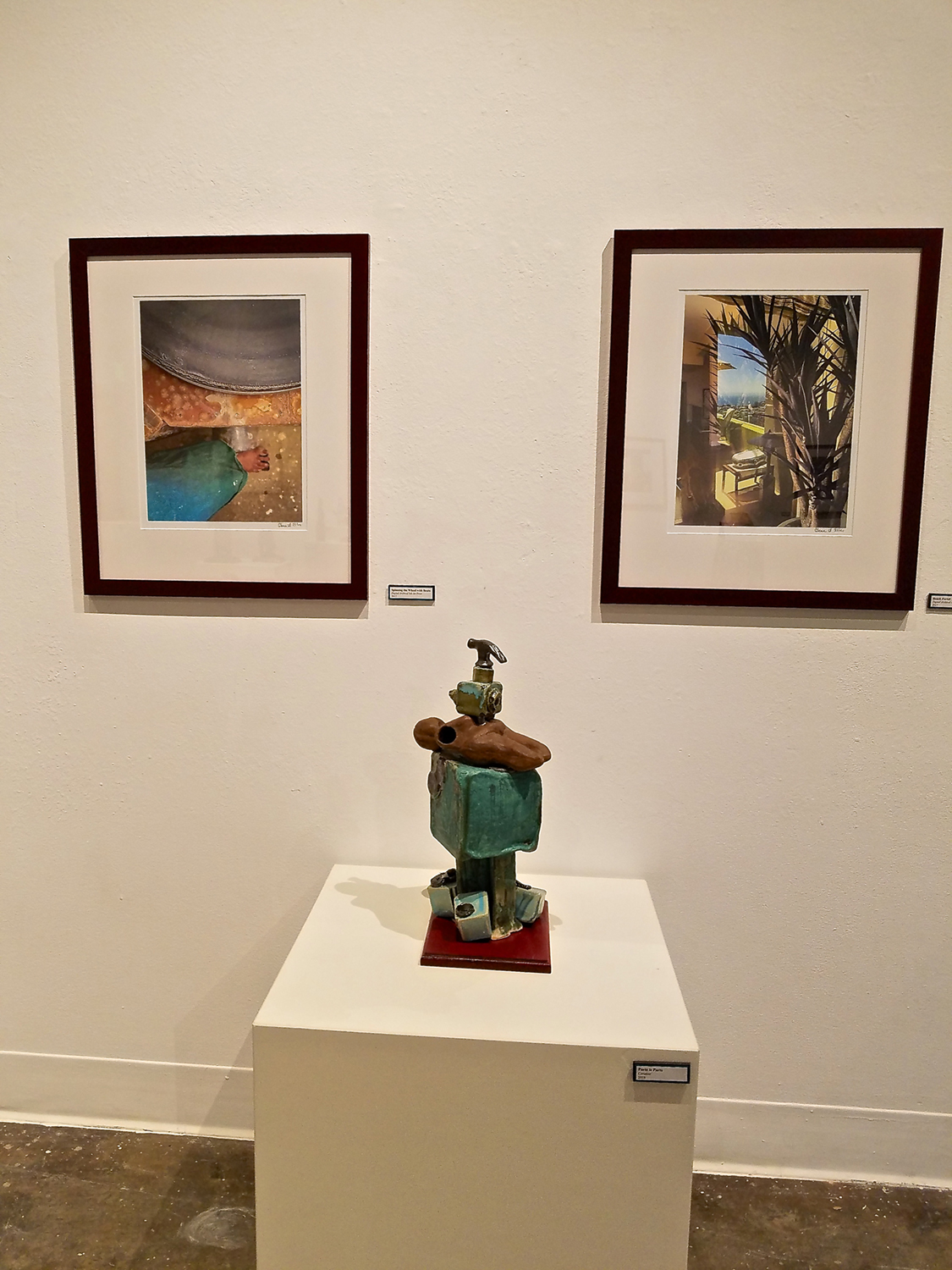 Ceramic figure on a pedestal between two paintings. Image courtesy of Olena Ellis