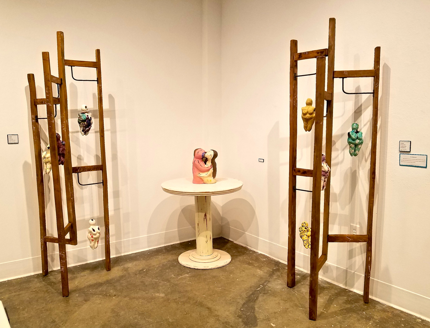 Ceramic goddesses suspended on wire racks around the ceramic piece "The Kiss". Image courtesy of Olena Ellis
