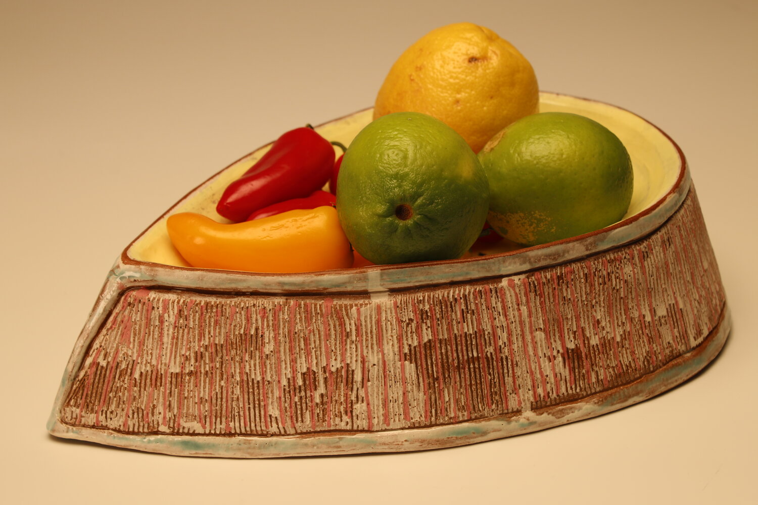 fruit stacked on top of the reversible almond-shaped ceramic colander, image courtesy of the artist
