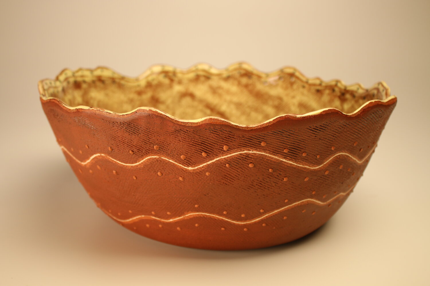 Large brown bowl with white inlay and undulating rim, image courtesy of the artist