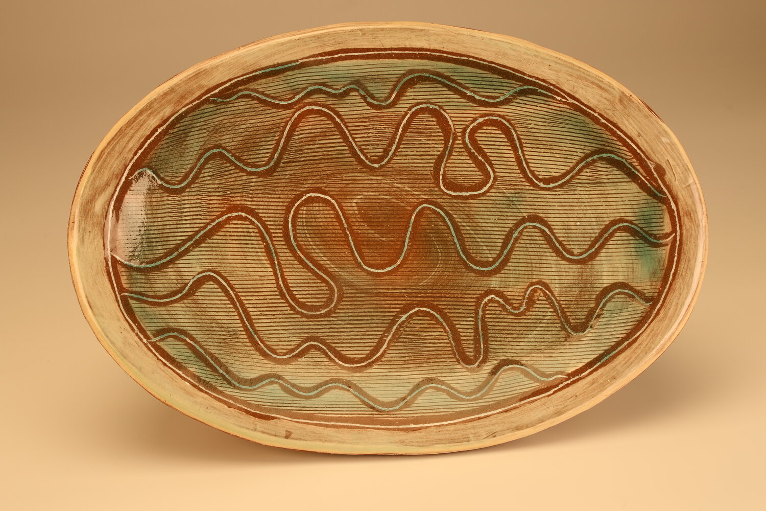 A shallow oval dish with freeform squiggle pattern inside, image courtesy of the artist
