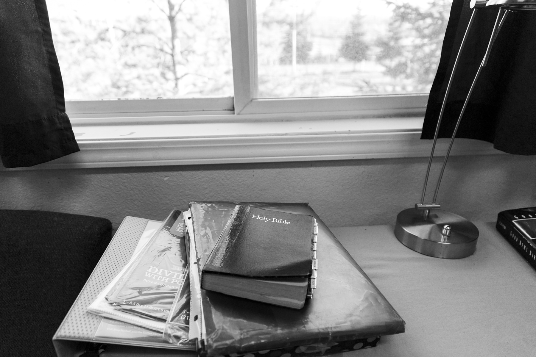 Morning light pours in through the window next to Felicia Cavanaugh’s bed onto her bible and other books sitting on her table at the Fairbanks Rescue Mission on April 28th 2018. Courtesy of the artist