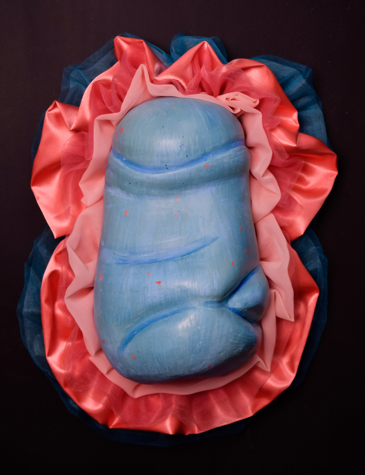 Ceramic sculpture of male genitalia on a fabric pillow, courtesy of the artist