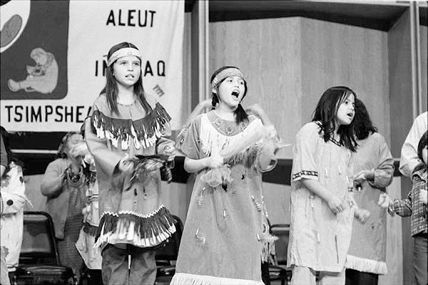 Three girls in traditional dress sing during an early Festival of Native Arts. Alaska and Polar Regions Collections, Elmer E. Rasmuson Library, University of Alaska Fairbanks.