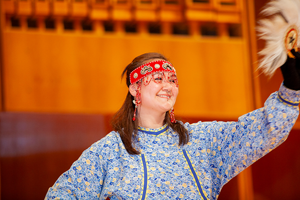 A performer in a blue traditional dress, adorned with a red beaded headband, smiles during the 2009 Festival of Native Arts. UAF photo by Todd Paris.