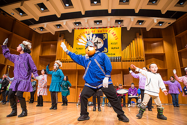 Performers wearing kuspuks, including a man with a unique mask, dance on stage at the 2018 Festival of Native Arts. UAF photo by JR Ancheta.