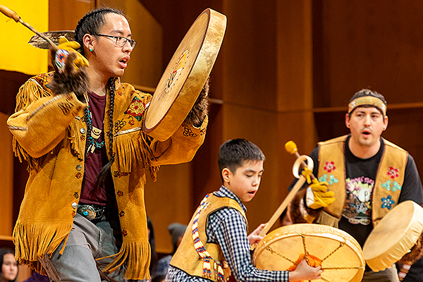Three drummers dressed in traditional attire play during day three of the 2024 Festival of Native Arts. UAF photo by Leif Van Cise.
