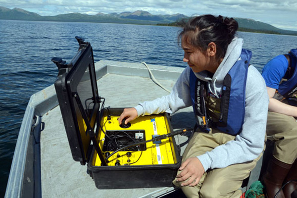 Student using testing equipment on a boat